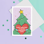 Load image into Gallery viewer, A cute Christmas card featuring a cartoon Christmas tree hugging a large love heart. The love heart reads, &quot;Happy Christmas to the most wonderful Gran&quot;. A yellow star is on the top of the tree set against a light purple snowy background with love hearts.
