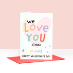 Load image into Gallery viewer, A colourful pastel card with the words we love you happy Valentines day, with space for personalising with a name. The card features a light pink heart in the background overlayed by soft multicoloured text.
