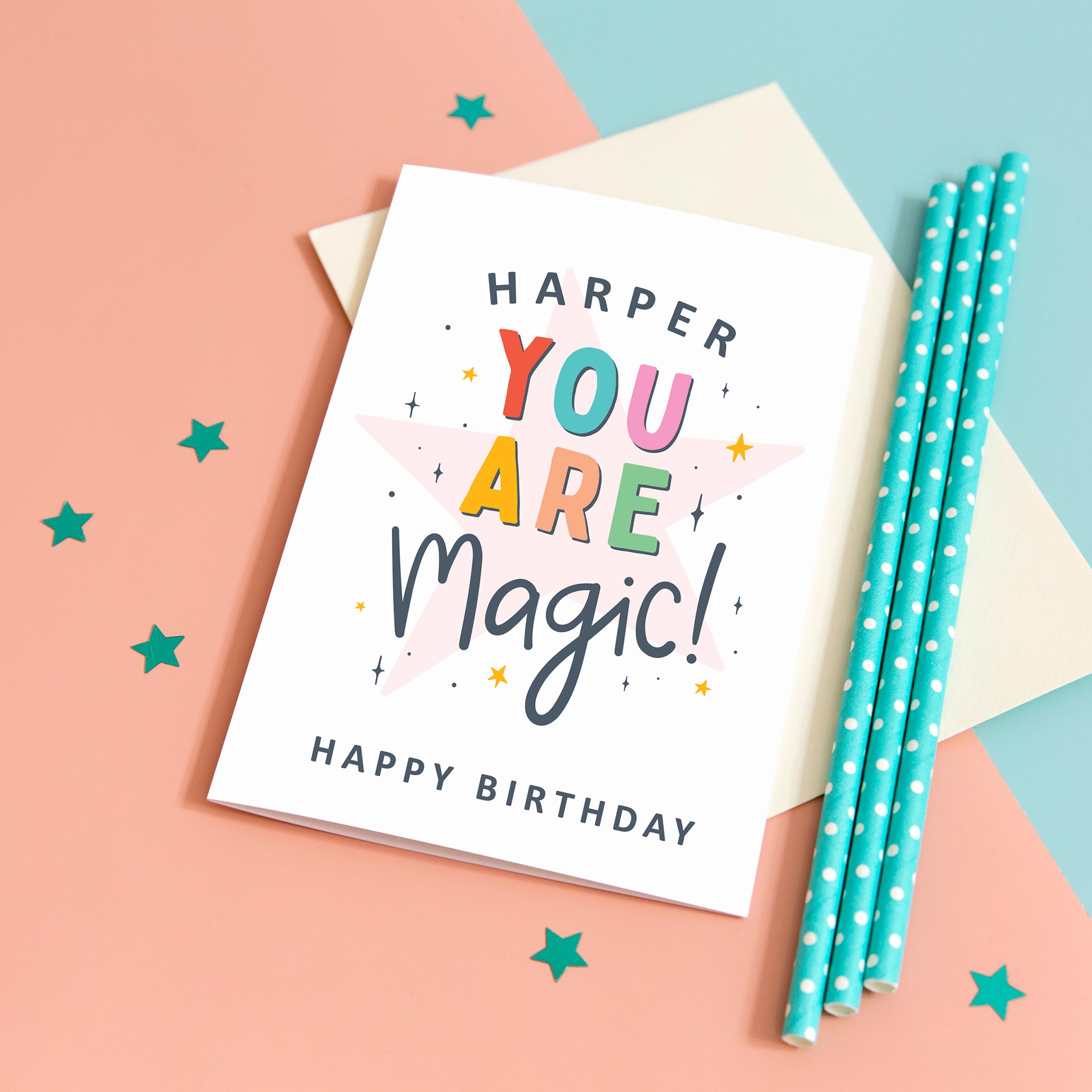 A colourful typographic card with a personalised name and the words 'you are magic! Happy birthday'. The card features a large light pink star in the background with a collection of smaller stars around the lettering.